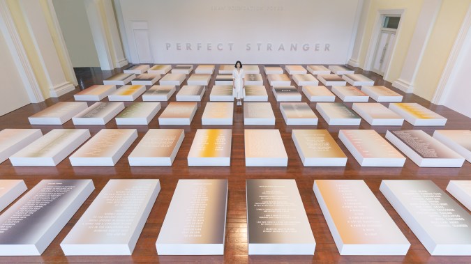 An sweeping view of Singaporean artist Dawn Ng's contemporary installation, Perfect Stranger, which shows a sea of paper in a gradient of words and colour.