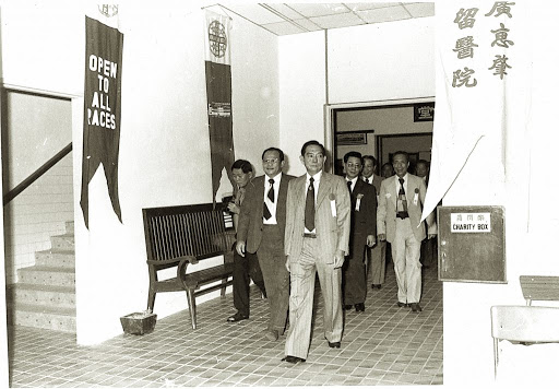 An old photograph of Kwong Wai Shiu Free Hospital in 1974 with banners inviting patients of all races.