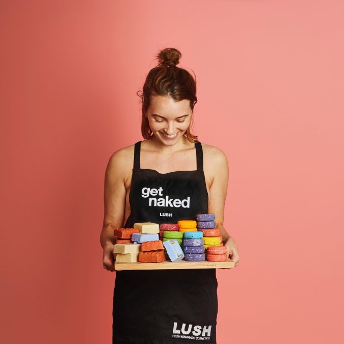 A model is carrying a tray of Lush's Naked products, which are basically packaging-free items - ranging from soaps and shampoos to make up.